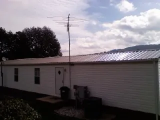 New metal roof on a single wide mobile home with a TV antenna in Blountstown
