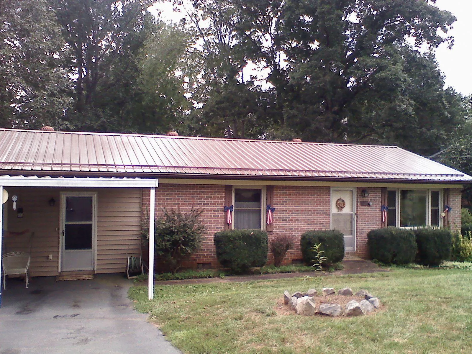 Bronze metal roof and carport on a brick ranch home — Roof Repair work by our crew in Blountstown
