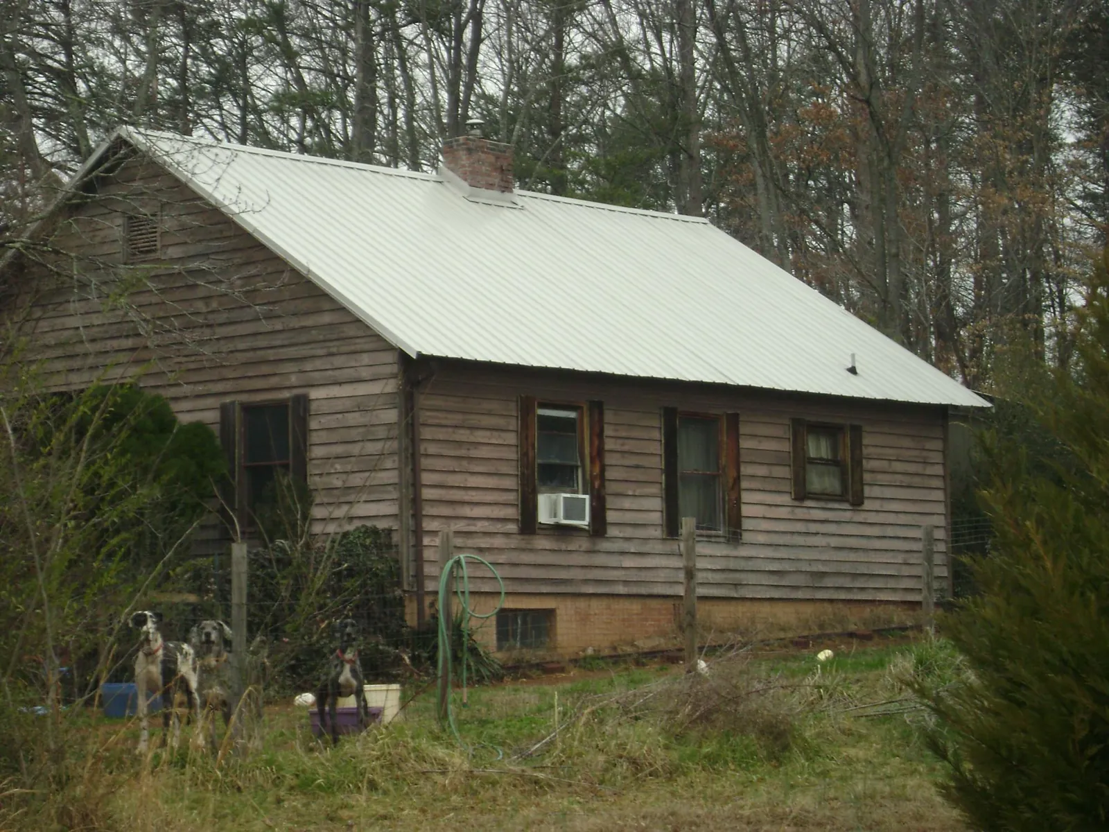 White metal roof on an old wood sided farmhouse, from a Metal Roof Installation job in Blountstown